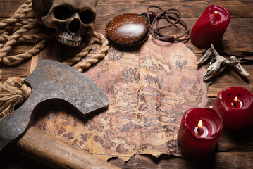 Ancient map, battle axe and burning candles on the top view table background.
