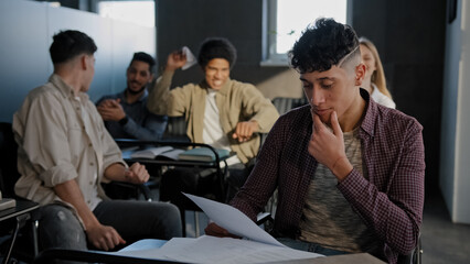 Nerd student sits in classroom at desk alone reads summary suffers from cruel aggressive attitude...