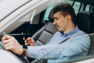 Man driving his car and using mobile phone