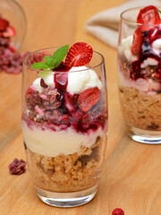 pink granola with strawberries and currants in a glass close-up