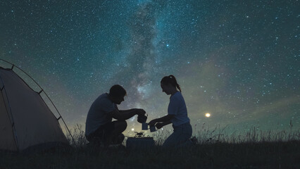 The two travelers preparing tea at the campsite on a starrying sky background