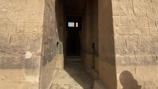 back view of woman visiting the Temple of Philae dedicated to Isis, goddess of love. Aswan. Egyptian
