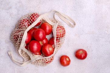 Large raw red tomatoes in a mesh bag