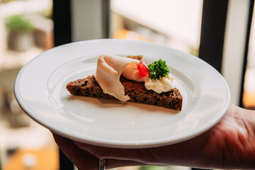 Appetizing sandwich with meat slices, herbs and white sauce on a plate.