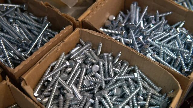 Steel, metal bolt screws fasteners. Stack of different fixing nuts in cardboards at industrial hardware shop for building, construction, home work and repairing.