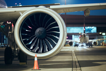Close-up of jet engine of plane at airport. Preparation of airplane before night flight.