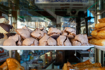 Appetizing sweets dipped in chocolate in a patisserie.