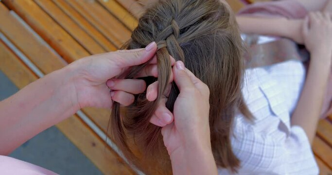 Girl braiding french braid her friend