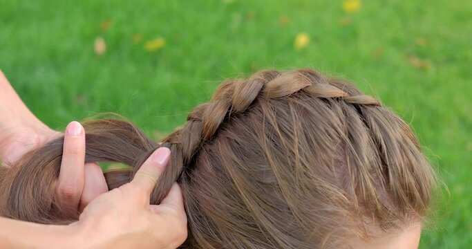 Girl braiding french braid her friend
