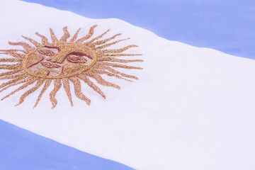 Argentine flag with embroidered sun in gold threads. Copy space