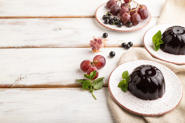 Black currant and grapes jelly on white wooden. side view, copy space.
