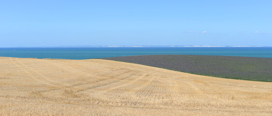 The white cliffs of Dover as seen from harvested agricultural fields along the French opal coast in the village Escalles in the department Pas-de-Calais on a sunny summer day