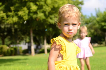 Portrait of a cute little girl in a yellow dress. Baby 2 years old. blond hair, blue eyes. Concept: happiness of motherhood, children's joy, kindergarten, children's health