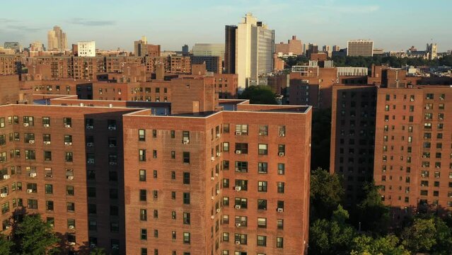 cinematic aerial trucking shot along public housing project buildings in Harlem New York City just after sunrise