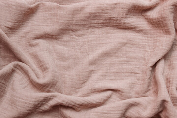 Light brown-pink cotton muslin fabric close-up with empty space for text, copy space, crumpled and with folds, conception of abstract backgrounds, making clothes from natural materials, linen,  sewing - obrazy, fototapety, plakaty