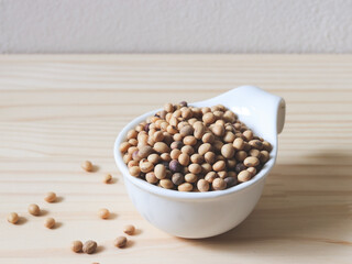 soy beans in white bowl on wooden table.
