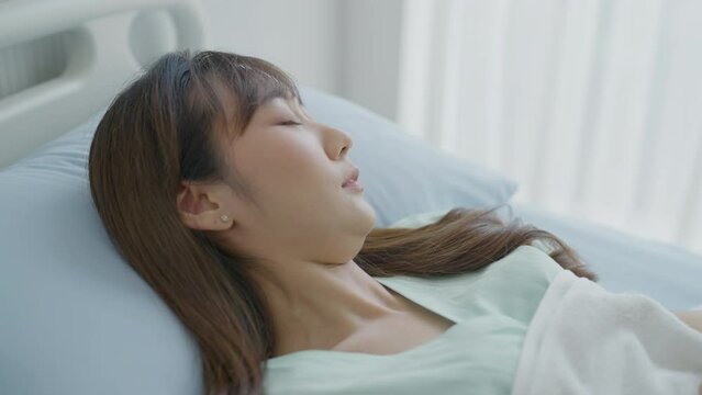 Young beautiful asian woman are coughing at bed in hospital. Healthcare, Medical, Lifestyle, Patient Concept.