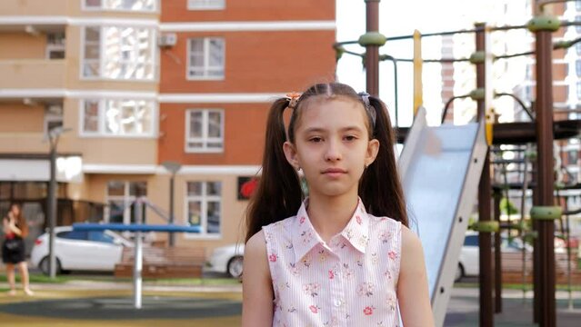 A preteen girl is walking on the playground.