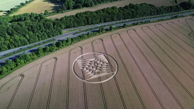 Drones took aerial video of crop circles in the UK's Micheldever Station of a field of yellow grain while there was close traffic.