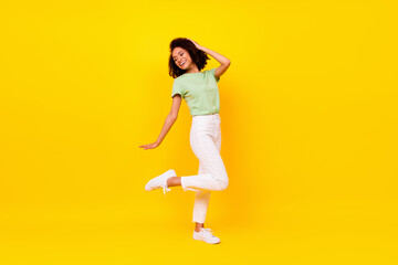 Fototapeta na wymiar Full length photo of funny brunette lady dance wear t-shirt jeans shoes isolated on vivid yellow color background