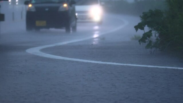 土砂降りの中で走行する自動車　大雨　暴風雨