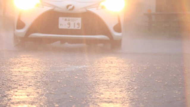 土砂降りの中で走行する自動車　大雨　国道　交差点