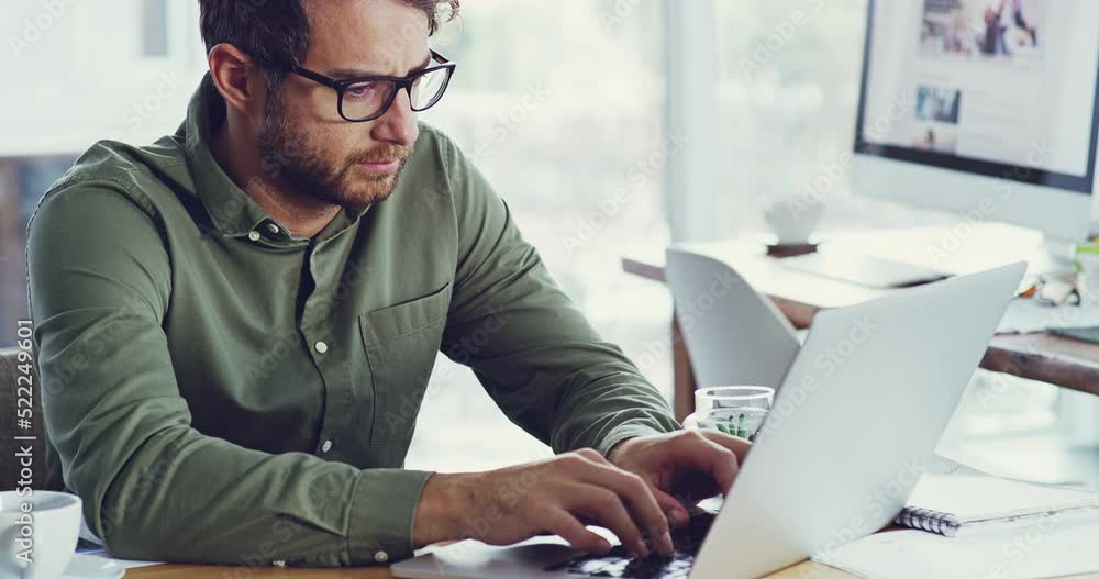 Poster serious man thinking and typing on a laptop while working in a creative office. male web designer ad