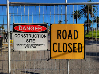 Construction site warning signs in yellow informing of road closure. Danger Construction Site sign...