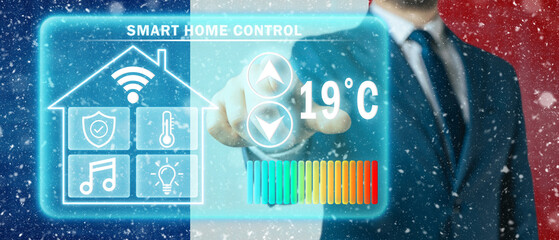 Frozen citizen of France adjusting heating temperature on a virtual screen of smart home...