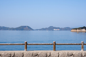 Obraz premium 大久野島から見る瀬戸内海を航行する大型旅客船とのどかな海と島々の風景 広島県竹原市た忠海町大久野島 The calm marine view of Setonaikai, Inland Sea of Japan, from Okunoshima island, Tadanoumi-town, Takehara-city, Hiroshima pref. 