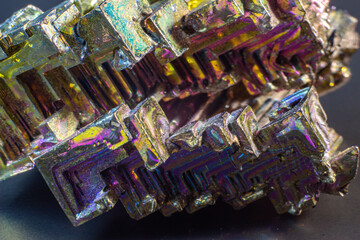 Bismuth bi close up on black surface.Interesting colour and shape crystal. Metal crystal