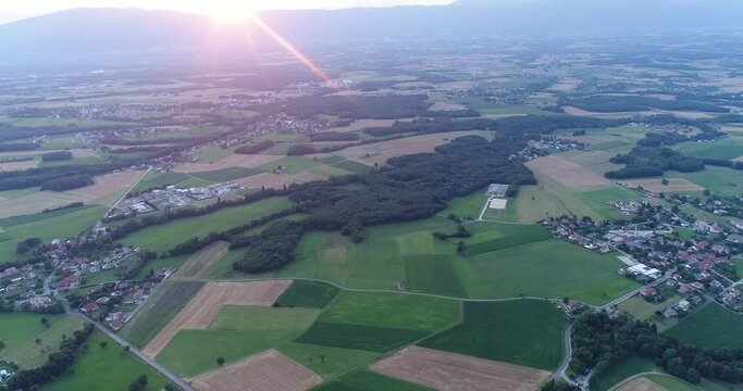 Aerial shot of countryside withsun setting down over mountain