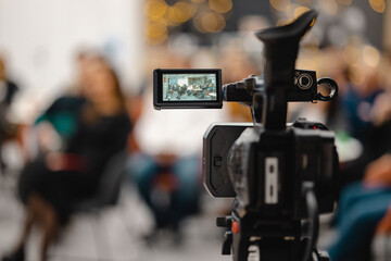 Close up of video camera streaming people at the event with blurred background