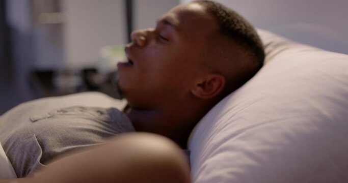 Exhausted, tired and worried woman tries to sleep in bed, wakes up from husband snoring, sinus problem or apnea. Long sleepless night for female partner with noise from male asleep in bedroom.