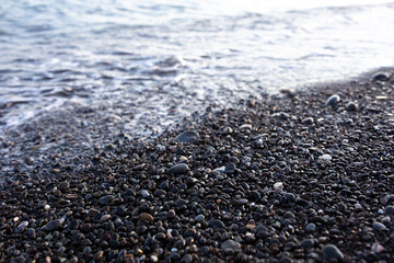  Seashore with pebbles and stones in the evening at sunset