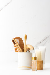 Wooden toothbrushes with natural bristles in a ceramic glass, face and skin care products, bottles with a pipette and a jar of cream, bath accessories, spa and beauty concept