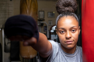 Young woman training on boxing bag, portrait