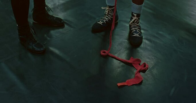 athlets are wrapping hands by protective tape in fight club, closeup of feet of two men, 4K, Prores