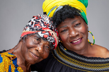 Portrait of senior woman and mature daughter wearing turbans
