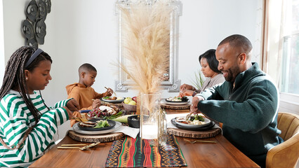 Family with children (8-9, 12-13) eating Kwanzaa meal