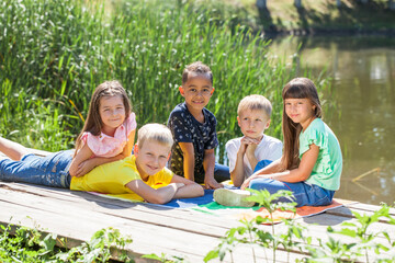 Five preschool children posing in a summer park