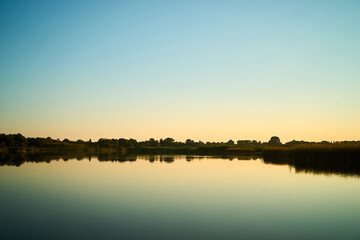 Sunset over a rural river with a blue sky in the background