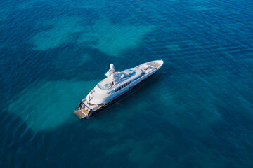 White big yacht for a billionaire anchored on a transparent aerial view. Mega yacht on blue top...