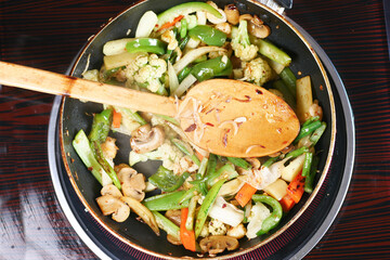 cooking fresh vegetables in a pan, top view 
