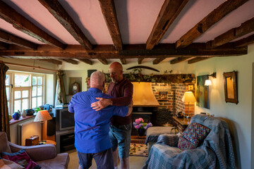 Senior male couple playing dancing at home