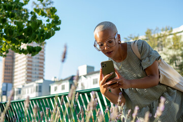 Young woman photographing lavender in city