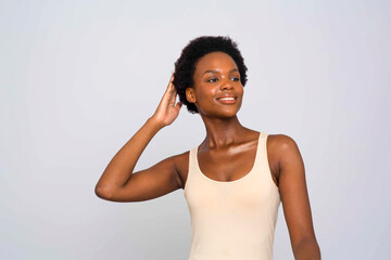 Studio portrait of smiling woman in cream colored tank top