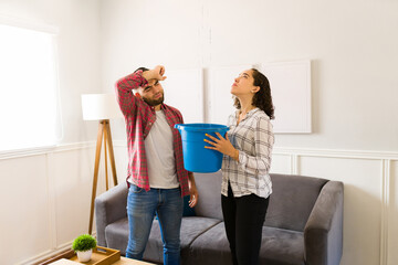 Stressed couple worried about repairing the leaks in the roof of their house