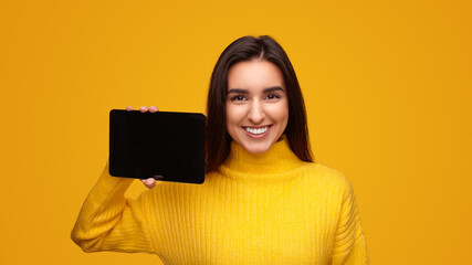 Friendly Hispanic woman showing tablet