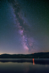 The Milky Way over the lake Schluchsee and the Black Forest in Germany.